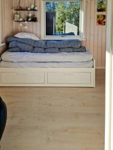 a bed in a room with a window at Renovated Beach House With Ocean View in Tjørneholm