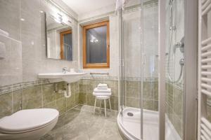 Un baño con inodoro, lavabo y ducha. en Marienstern Apartments, en Santa Cristina Valgardena 27 fotos más