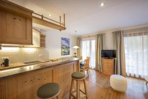 una cocina con encimera y algunos taburetes en Marienstern Apartments, en Santa Cristina Valgardena