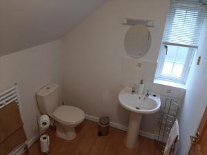 ein weißes Badezimmer mit Toilette und Waschbecken in der Unterkunft Forge Cottage - 28221 in Shaldon