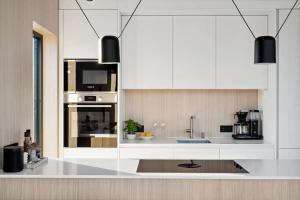 a kitchen with white cabinets and a sink at Serene cabin in Lofoten with sauna in Storøya +46 photos