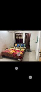 a bedroom with a bed with a colorful blanket at Gurukrupa Home stay in Rājpīpla