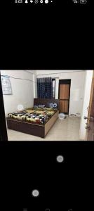 a bedroom with a bed in a room at Gurukrupa Home stay in Rājpīpla