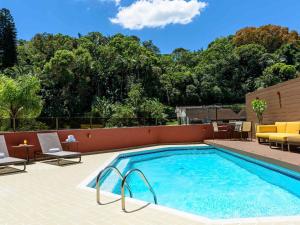 una piscina en un patio con sillas y mesa en Apartamento no Hotel Prinz, en Joinville