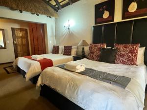 a bedroom with two beds with towels on them at Khaya Africa Guesthouse in Midrand +29 photos