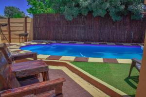 a swimming pool in a backyard with a wooden fence at Modern and Executive 2 Bedroom Townhouse in Bloemfontein