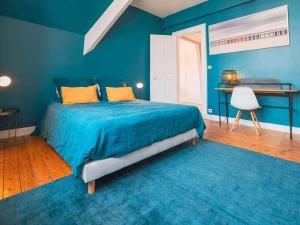 ein blaues Schlafzimmer mit einem Bett und einem Schreibtisch in der Unterkunft Appartement lumineux au centre-ville du Touquet - FR-1-821-28 in Le Touquet-Paris-Plage + 1 Foto