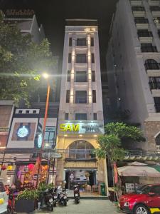 a tall building with a sign on the front of it at SAM Hotel and Apartment in Da Nang