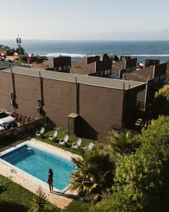 ChacurraにあるCabañas Entremarの海辺のスイミングプールの横に立つ女性