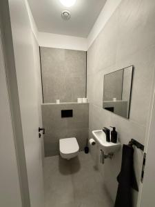 ein Badezimmer mit einer weißen Toilette und einem Waschbecken in der Unterkunft The Blue Church Family Apartment Old Town Self Check-in 6 guest in Bratislava