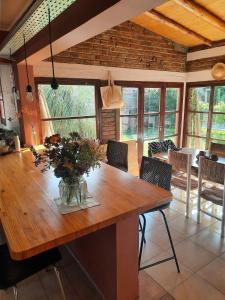 une salle à manger avec une table en bois et un vase de fleurs dans l'établissement La Casa de Ana, à San Rafael