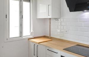 une cuisine avec des armoires blanches et un comptoir en bois dans l'établissement Amazing Apartment In Barbate With Wifi, à Barbate
