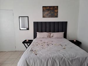Un dormitorio con una cama grande con cabecero negro. en Buccleuch Home, en Sandton