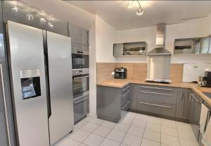 a kitchen with stainless steel appliances and gray cabinets at Gîte Le Flot in Saint-Florentin
