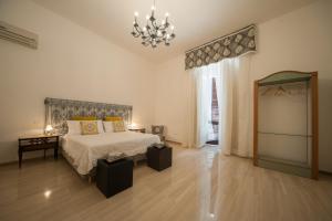 ein großes Schlafzimmer mit einem Bett und einem Kronleuchter in der Unterkunft Suite San Giorgio in Trani