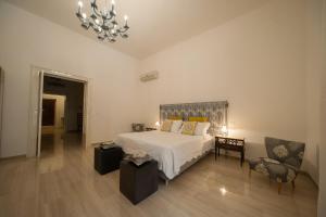 ein Schlafzimmer mit einem weißen Bett und einem Kronleuchter in der Unterkunft Suite San Giorgio in Trani