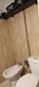 a bathroom with a white toilet and a sink at Kasty in Piriápolis +16 photos