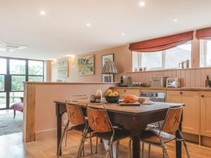 a kitchen with a table with a bowl of fruit on it at The Shearing Shed in Peasmarsh