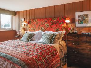 a bedroom with a large bed with a red headboard at The Shearing Shed in Peasmarsh +21 photos