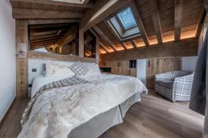 een slaapkamer met een groot bed in een kamer met houten plafonds bij Chalet Saint Joseph in Les Allues