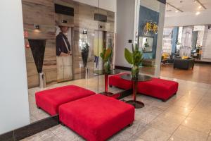a lobby with two red ottomans and a table at Golden Tulip Porto Vitória in Vitória