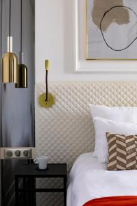 a bedroom with a white bed with a yellow side table at Oceania Hôtel d'Anjou Angers in Angers