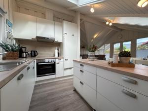 eine Küche mit weißen Schränken und einer Arbeitsplatte in der Unterkunft Ferienhaus Hein Mück in Glücksburg + 45 Fotos