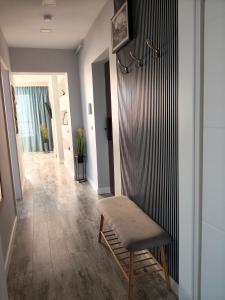 a living room with a chair and a hallway at Apartament Alex in Sibiu