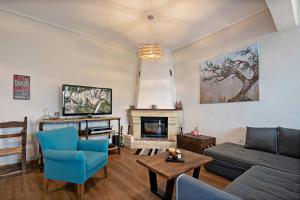 een woonkamer met een bank en een open haard bij Casa Sofia, By Hellocrete in Spílion