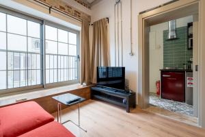 a living room with a red couch and a tv at Stone studio just a 3min walk from the Clock Tower in Konak