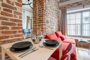 a living room with a table and a red couch at Stone studio just a 3min walk from the Clock Tower in Konak