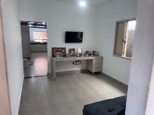 ein Wohnzimmer mit Schreibtisch und Fernseher in der Unterkunft Casa Férias Xero in Capitólio