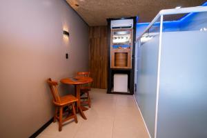 un corridoio con tavolo, sedie e frigorifero di Jardins Motel (Adults Only) a Maceió