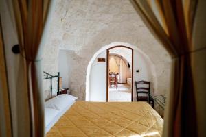 a bedroom with a bed and an arched doorway at Trulli Il Castagno in Martina Franca +236 photos