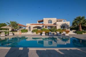 a villa with a swimming pool in front of a house at Villa Elia, By Hellocrete in Astérion