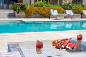 a plate of fruit on a table next to a swimming pool at Villa Elia, By Hellocrete in Astérion