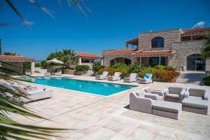 a villa with a swimming pool with lounge chairs and a house at Villa Elia, By Hellocrete in Astérion +46 photos
