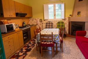 een keuken met een tafel met stoelen en een magnetron bij Casa Vacanze Chimenti in Tarsia