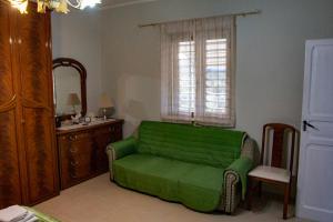 een groene bank in een kamer met een raam bij Casa Vacanze Chimenti in Tarsia