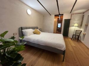 a bedroom with a bed with white sheets and pillows at Belvedere Apartments Valdilana in Trivero