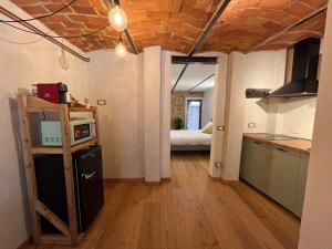 a room with a kitchen and a room with a bed at Belvedere Apartments Valdilana in Trivero