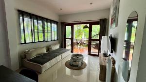 een woonkamer met een bank en een televisie bij Shanti samui Resort in Laem Sor