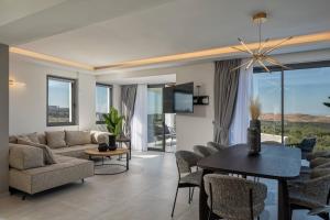een woonkamer met een bank, een tafel en stoelen bij Skyline Villas, By Hellocrete in Angeliana