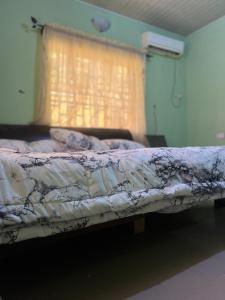een bed in een kamer met een raam bij Otam Homes in Ondo