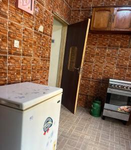 een keuken met een koelkast en een bakstenen muur bij Otam Homes in Ondo