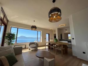 een woonkamer met een tafel en een groot raam bij SeaWave Villas, By Hellocrete in Chania