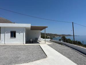 a white house with a view of the ocean at Agia Fotia Holiday House in Kerames