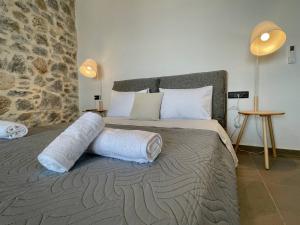 a bedroom with a large bed with towels on it at Ocean Bliss Villa, By Hellocrete in Kerames +45 photos