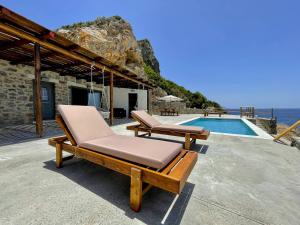 a couple of lounge chairs next to a swimming pool at Ocean Bliss Villa, By Hellocrete in Kerames