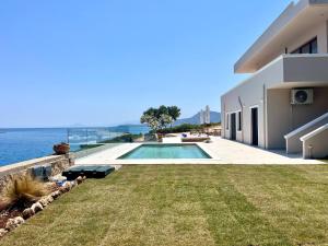 een huis met een zwembad naast het water bij SeaWave Villas, By Hellocrete in Chania